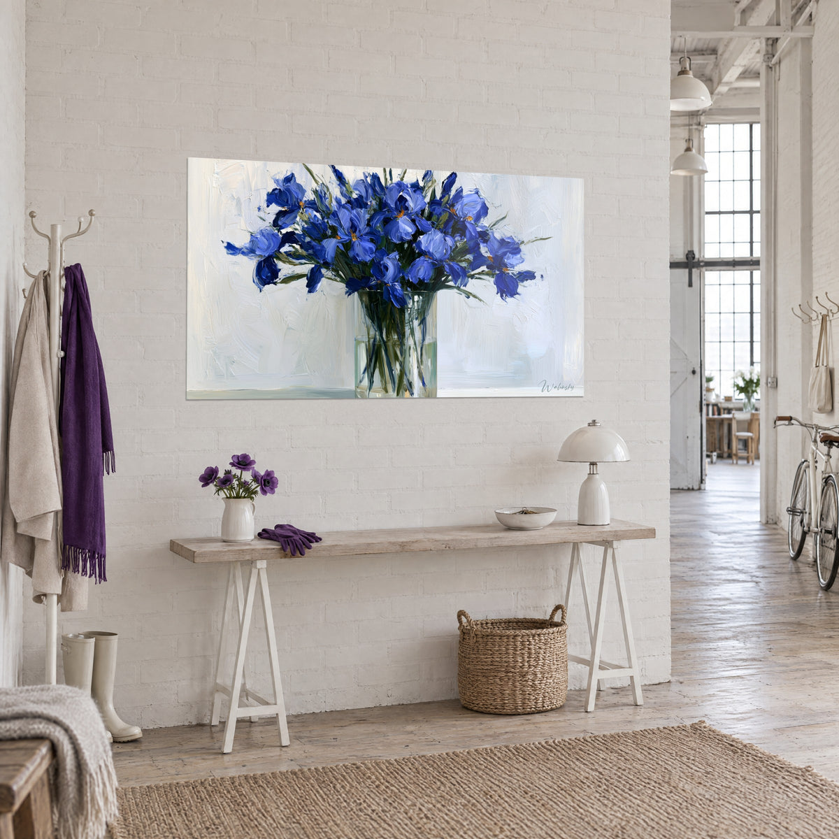 Tableau gerbe d'iris bleu cobalt aux cœurs orangés, vase cylindrique transparent, loft clair, vue de trois-quarts