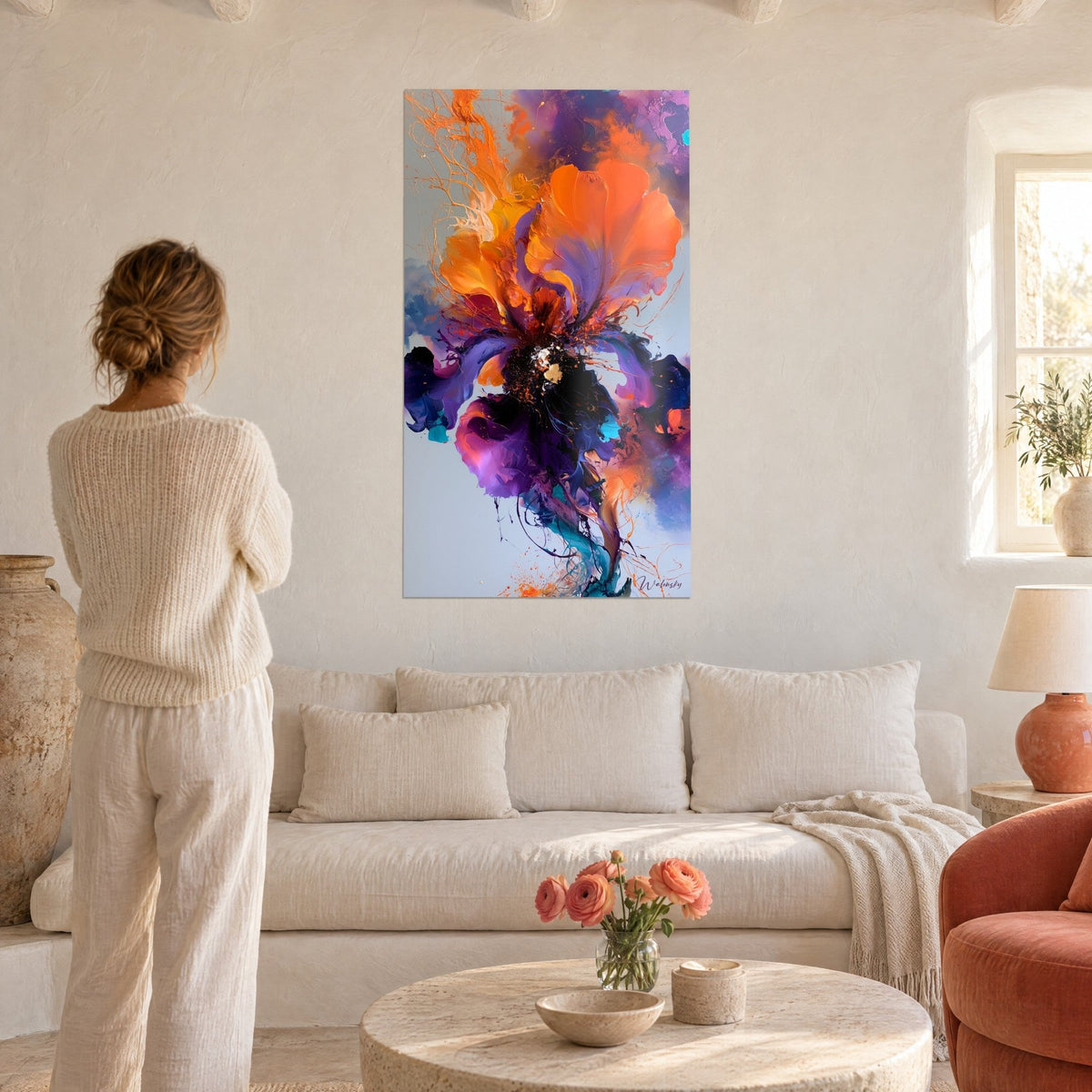 Gemälde Schwertlilie leuchtend in Orange und Violett, eine Frau von hinten über einem Sofa in einem hellen Wohnzimmer