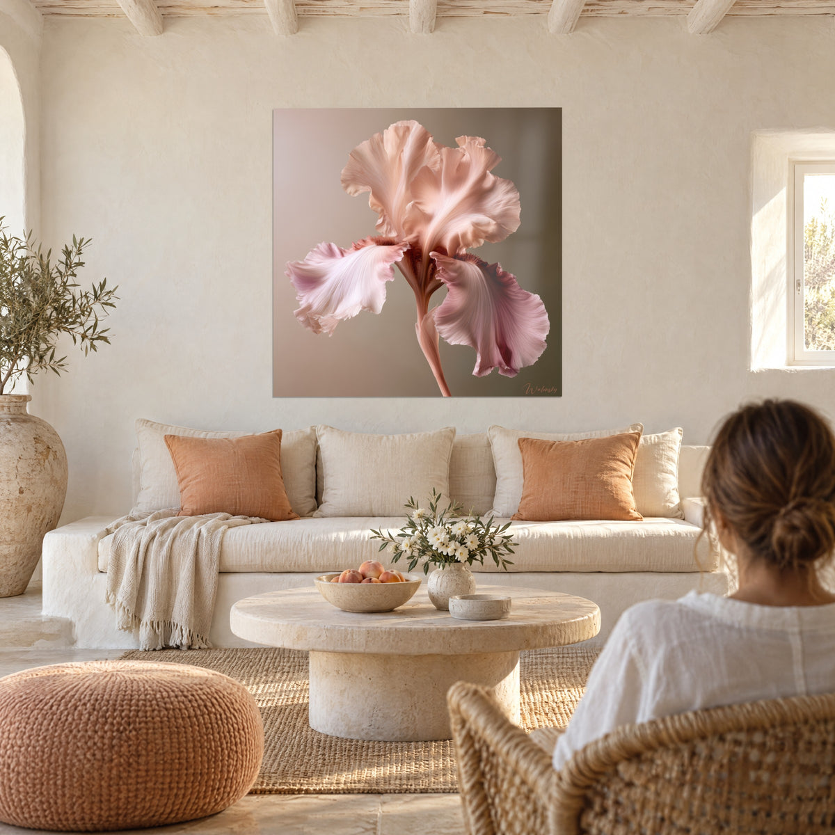 Gemälde Iris in Pfirsich mit gewellten Blütenblättern auf taupefarbenem Grund, eine Frau von hinten über einem Sofa in einem lichtdurchfluteten Wohnzimmer