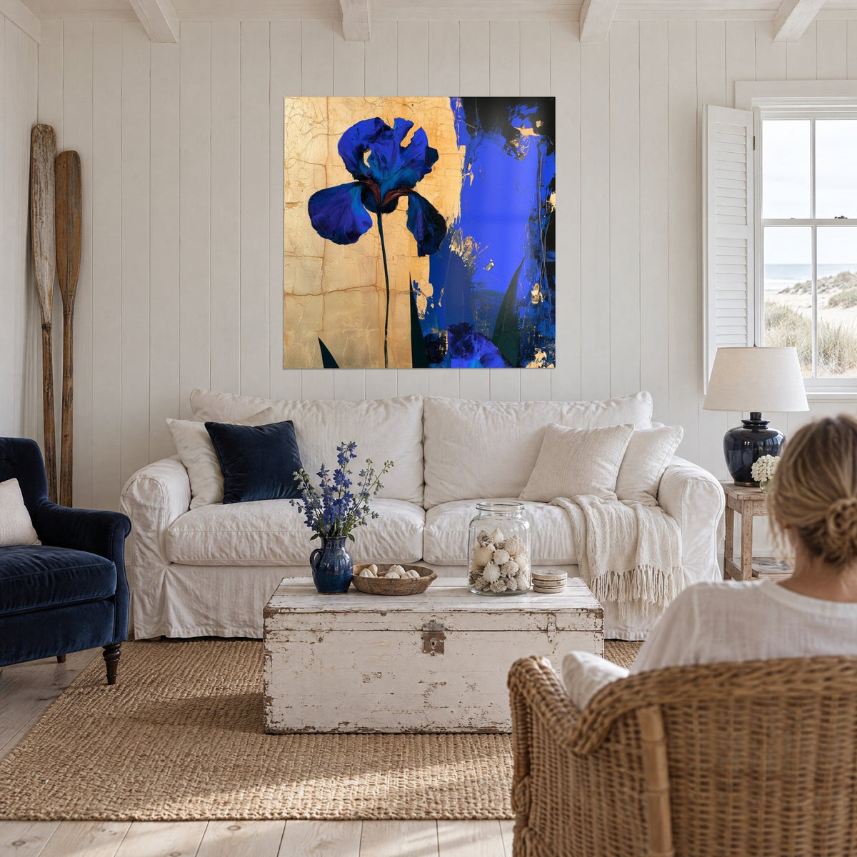 Wall art electric blue iris on cracked gold background, slender black leaves, hanging above a sofa in a bright living room