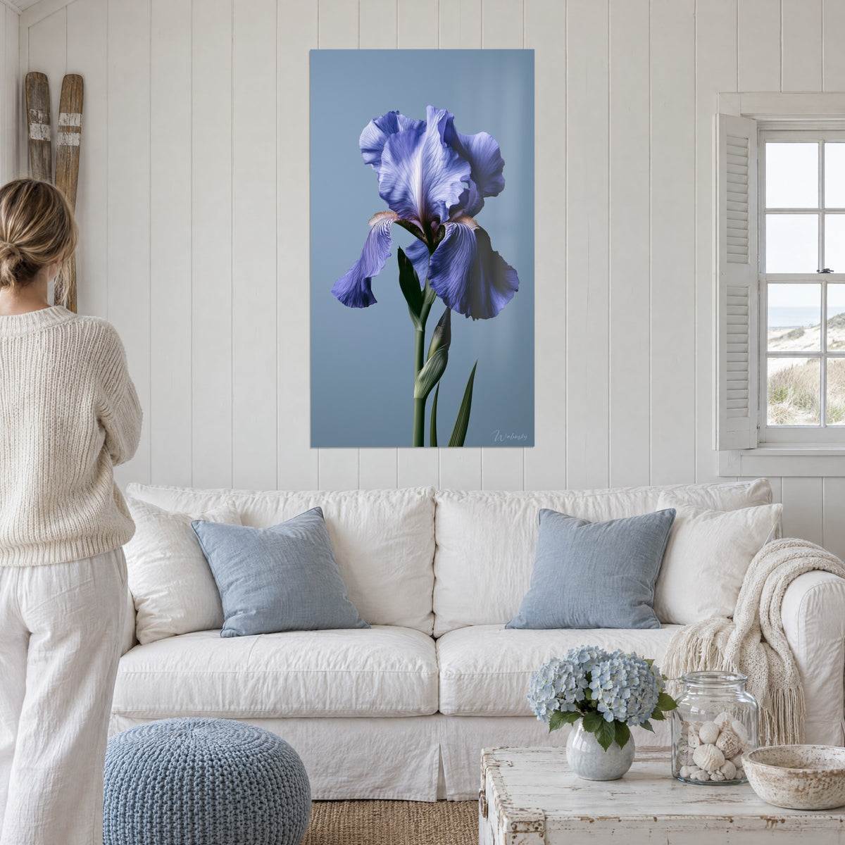 Wall art lavender-blue iris with wavy, veined petals, grey-blue background, hanging above a sofa in a bright living room