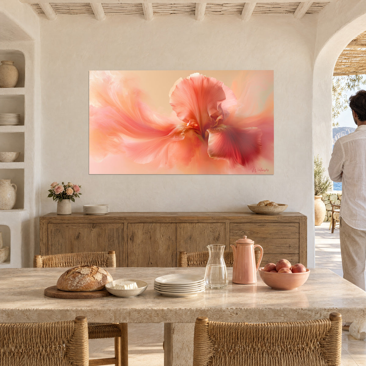 Cuadro iris con volutas de seda rosa salmón y naranja, estambres dorados, frente a una mesa de comedor y un arco blanco