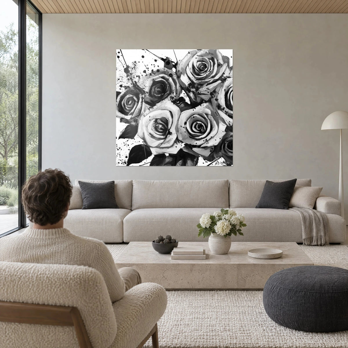Quadro bouquet di rose in bianco e nero, schizzi d'inchiostro, petali grigio argento, sopra un divano in un soggiorno luminoso