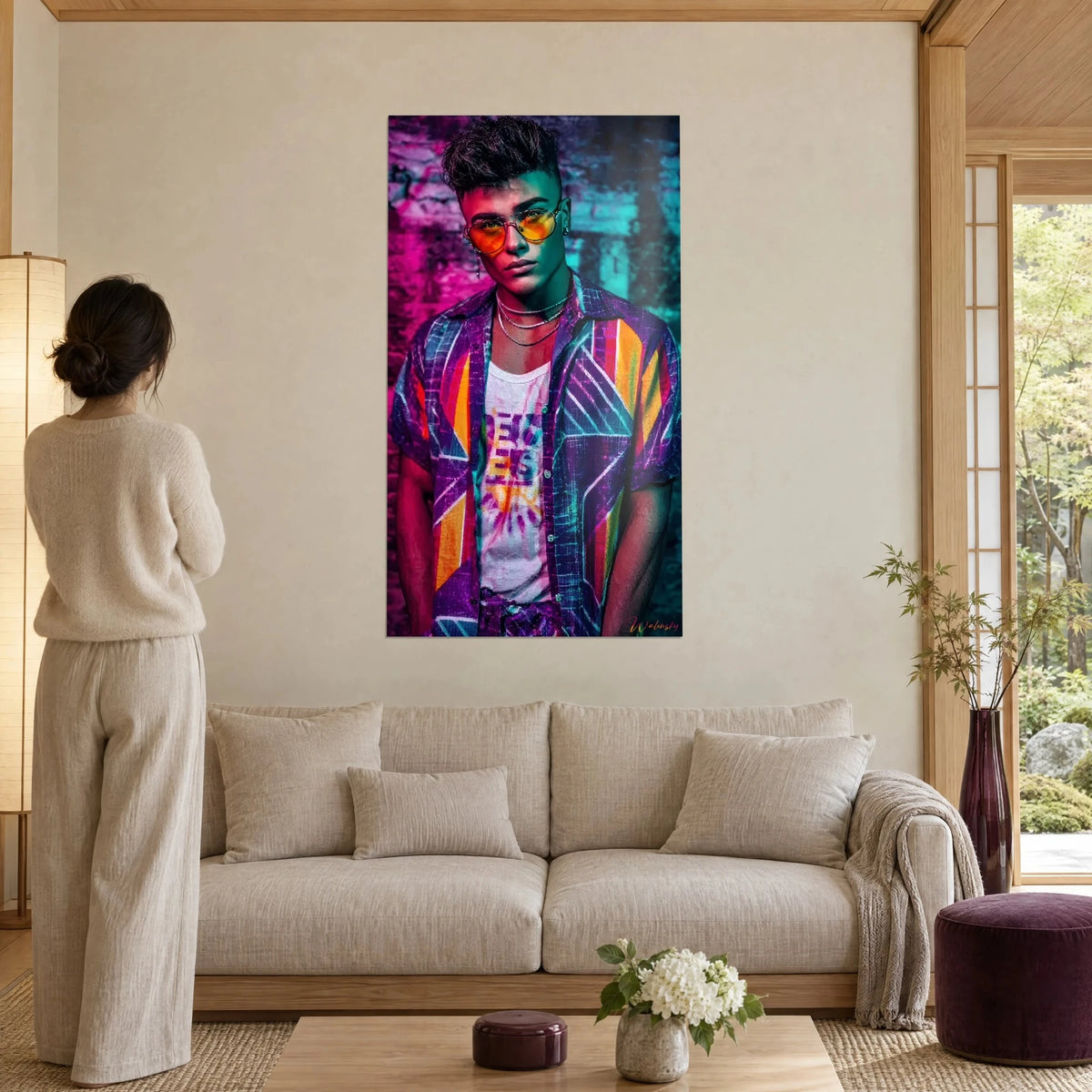 Wall art young man with orange glasses and purple geometric shirt in front of neon pink brick wall, above a sofa in a bright living room