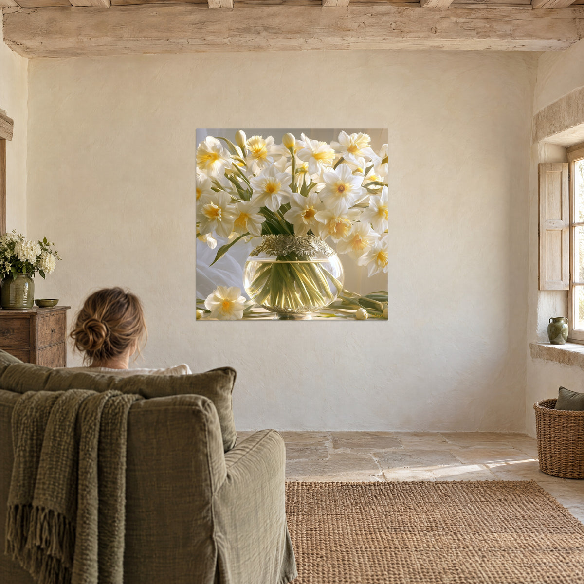 Quadro narcisi splendenti in un vaso di cristallo con bordo argentato ornato, donna di spalle su una poltrona verde oliva, parete di pietra chiara