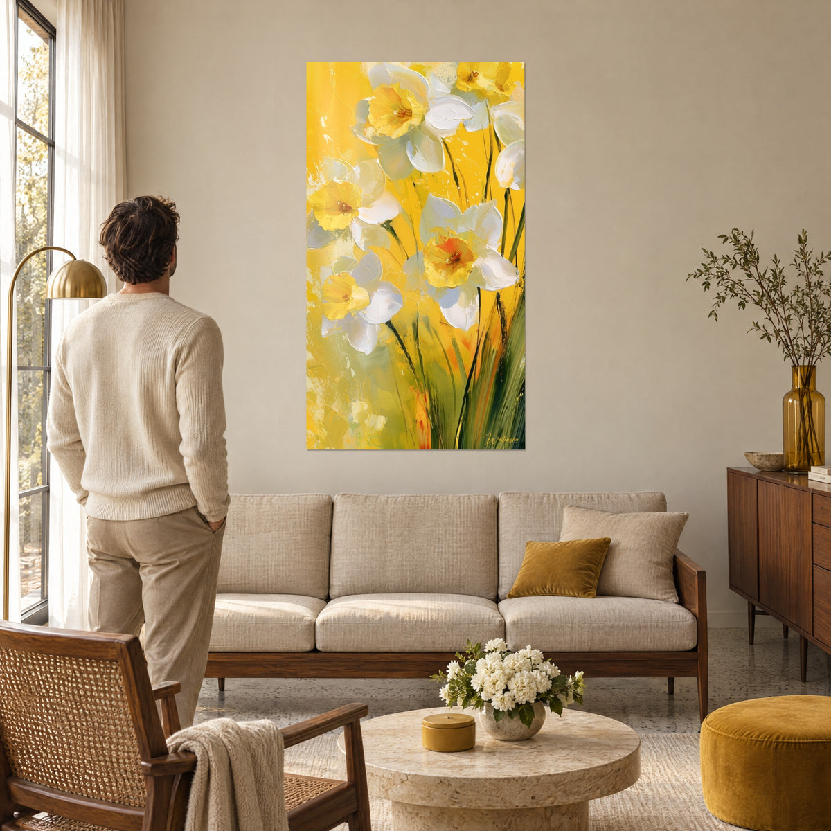 Cuadro narcisos marfil con corazón dorado sobre fondo azafrán, hombre de espaldas delante, encima de un sofá en un salón luminoso