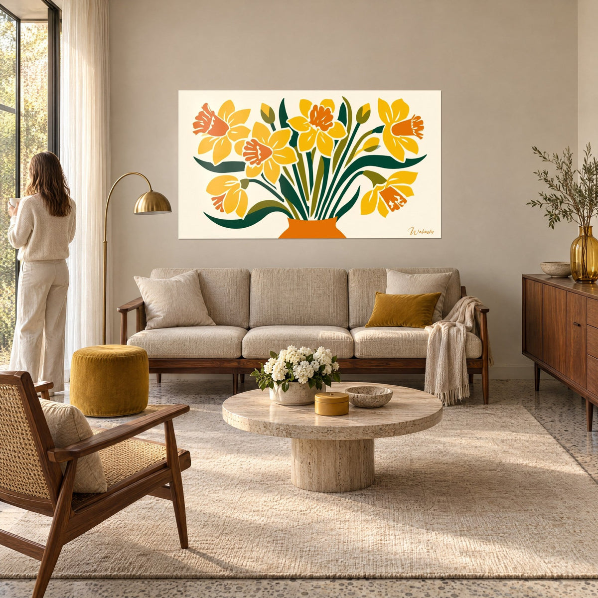 Tableau bouquet de jonquilles jaune safran dans un vase orange, feuilles vert sapin courbées, au-dessus d'un canapé dans un salon lumineux