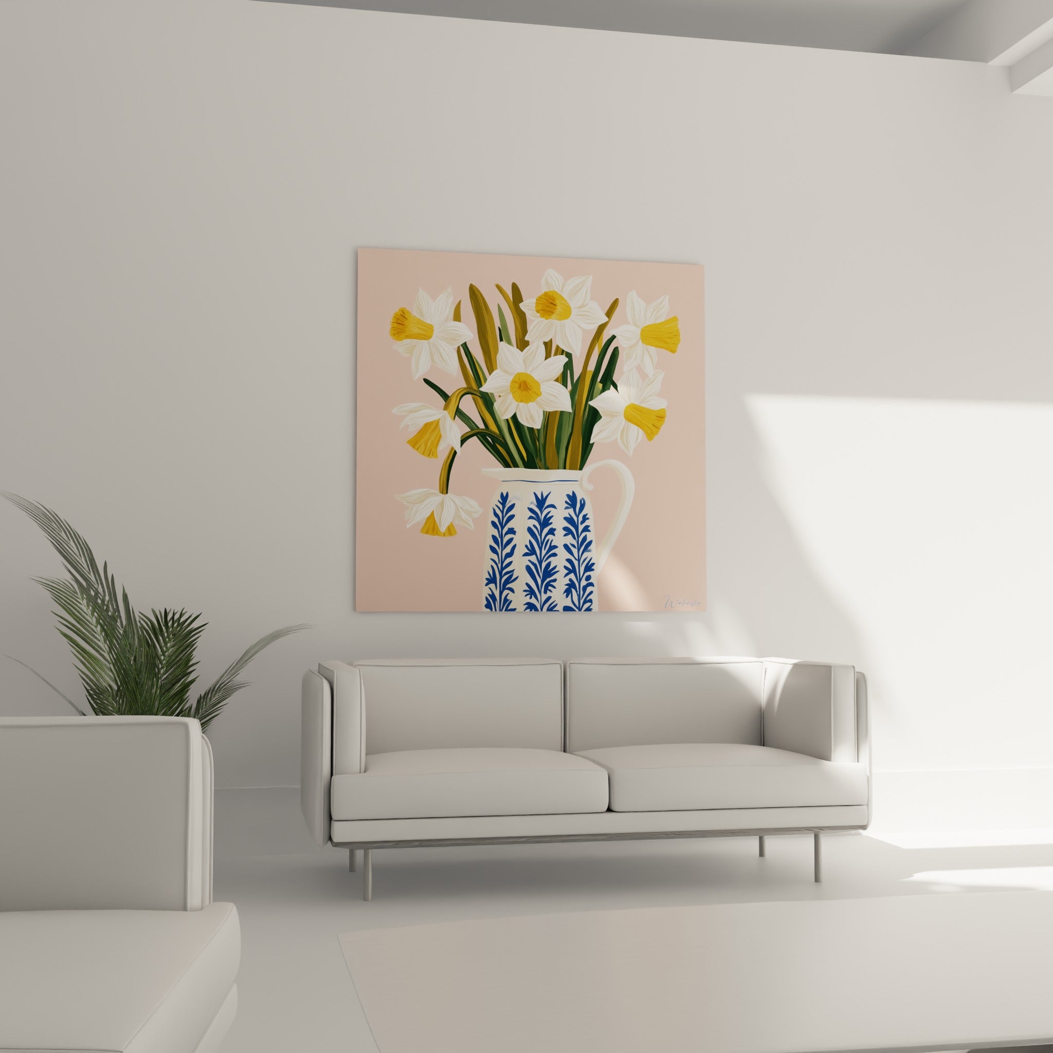 Pichet fleuri de jonquilles jaunes et rose pastel au-dessus d'un canapé dans un salon lumineux