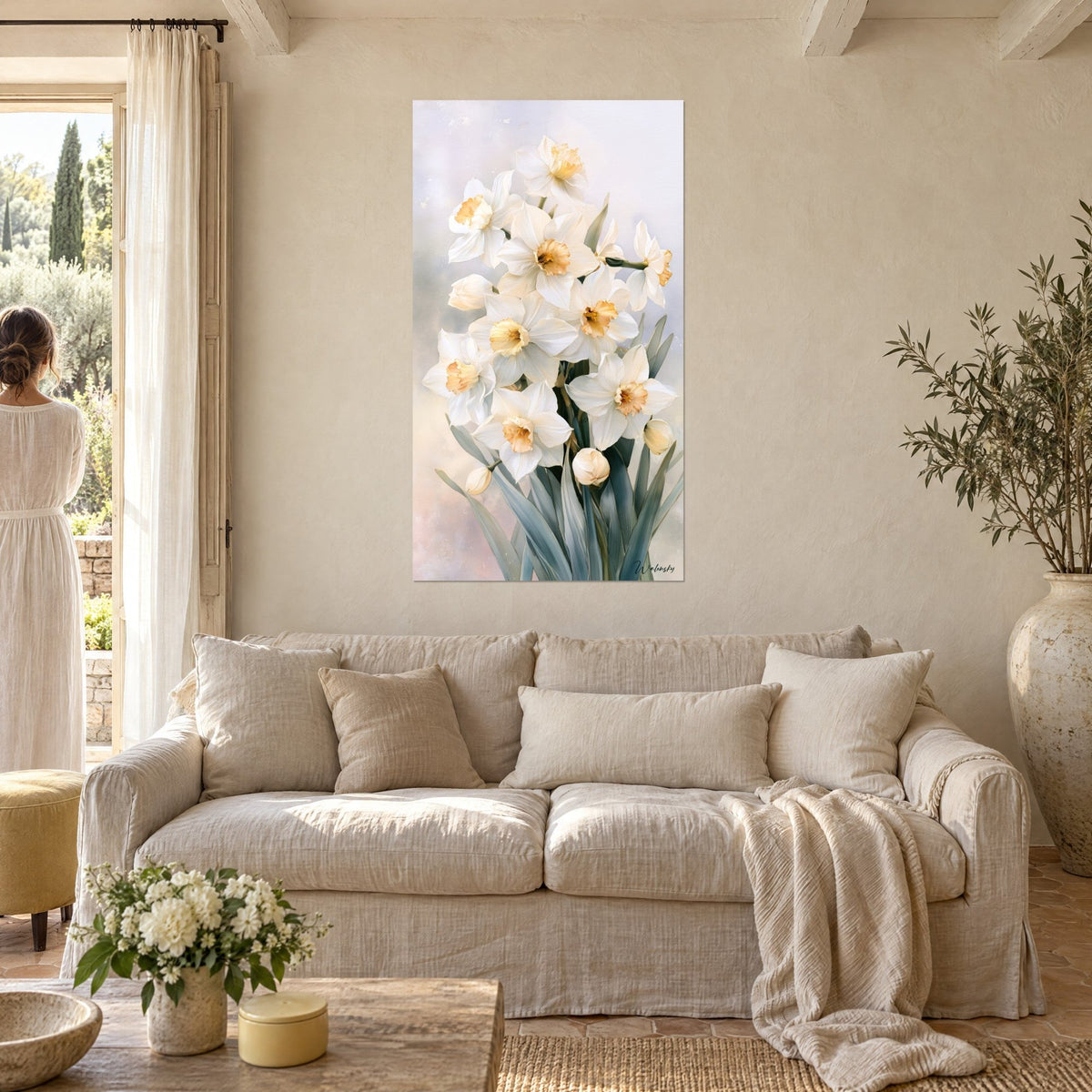 Quadro bouquet di narcisi bianchi dal cuore ambrato, fogliame grigio-azzurro, una donna di spalle sopra un divano in un soggiorno luminoso