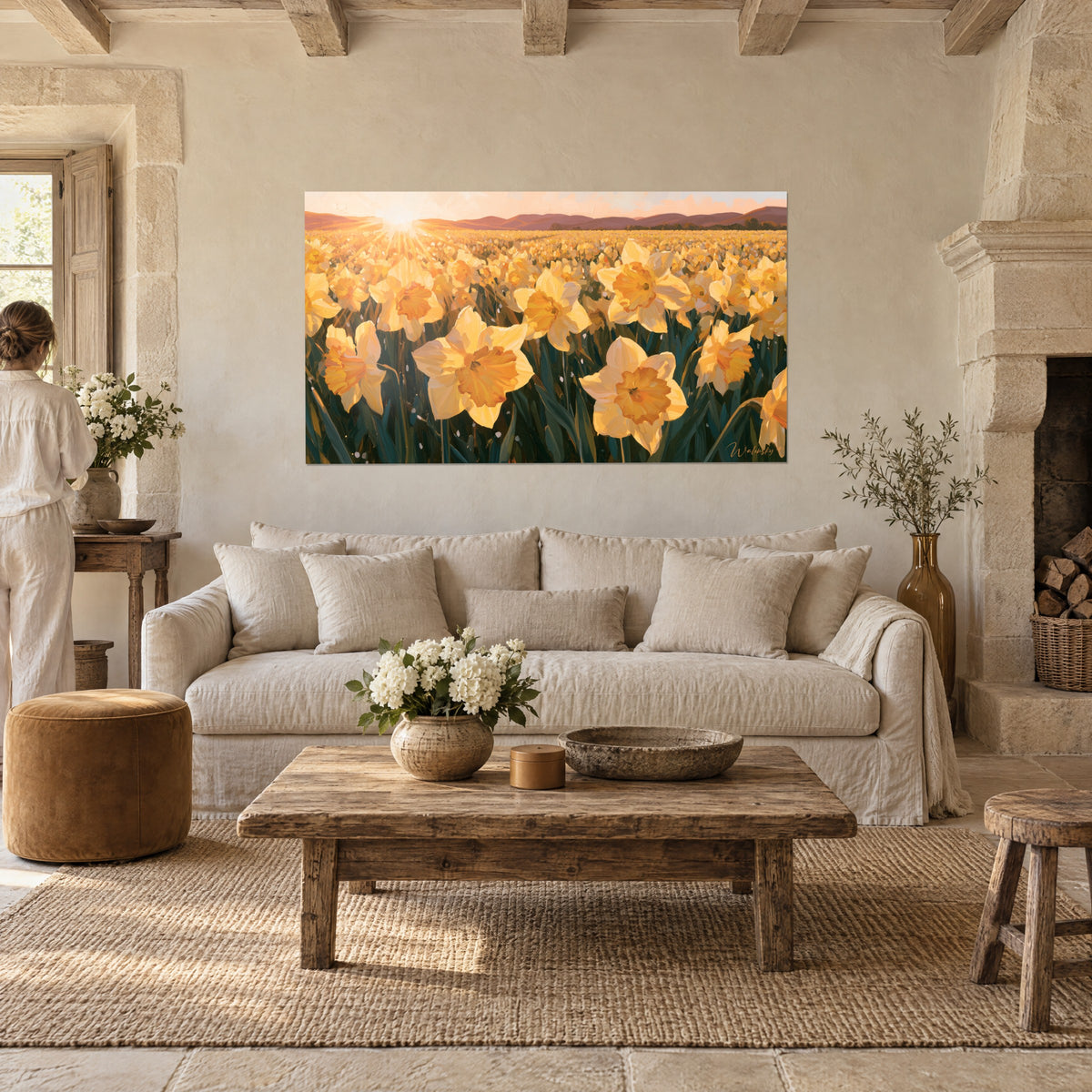 Schilderij veld met gele en oranje narcissen onder een stralende zon, paarse bergen in de verte, boven een bank in een lichte woonkamer