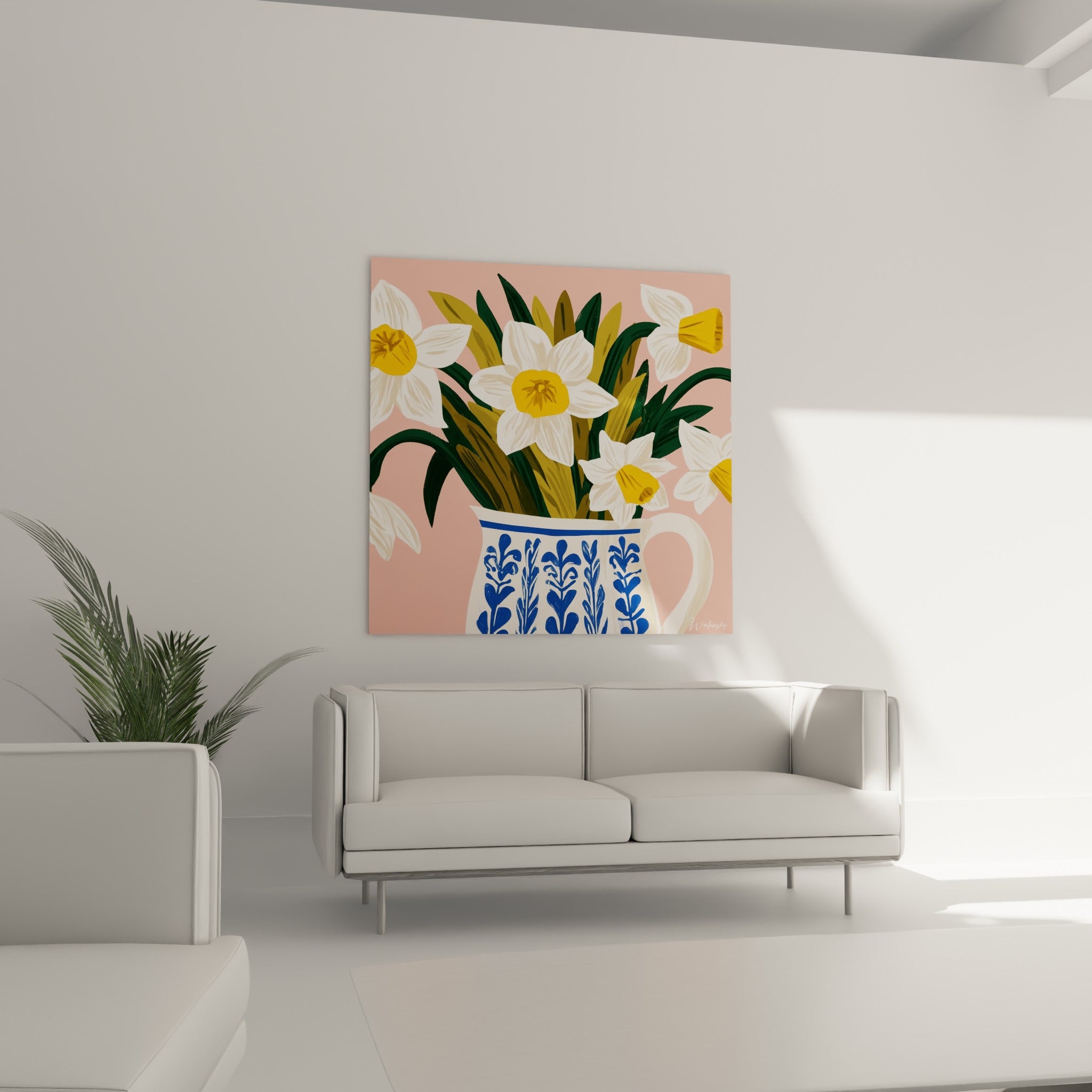 Fleurs de jonquille jaune vif et pichet à motifs bleus au-dessus d'un canapé dans un salon lumineux