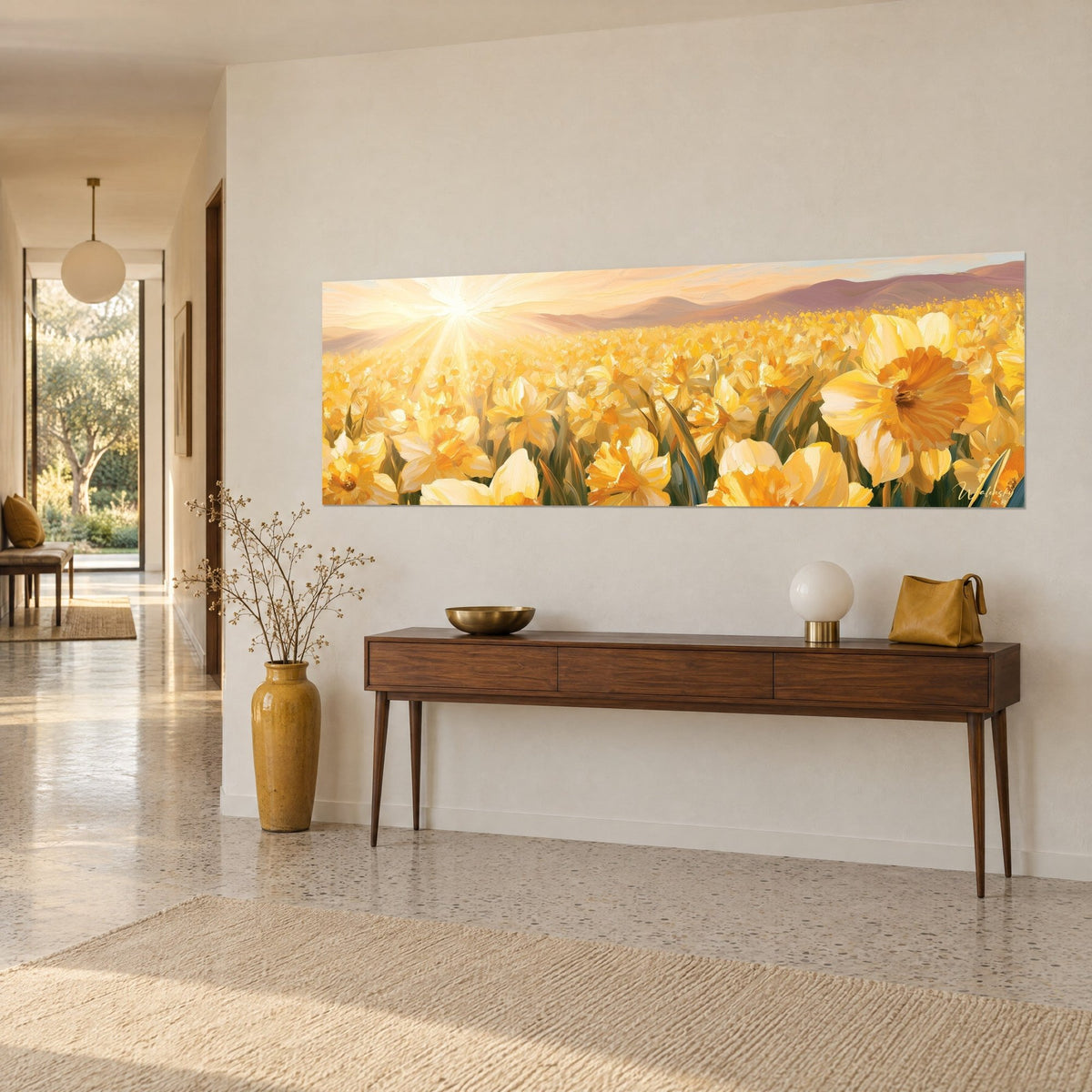 Cuadro panorámica de narcisos dorados, pétalos color mantequilla y corazones anaranjados, colinas malvas, sobre una pared crema encima de una consola