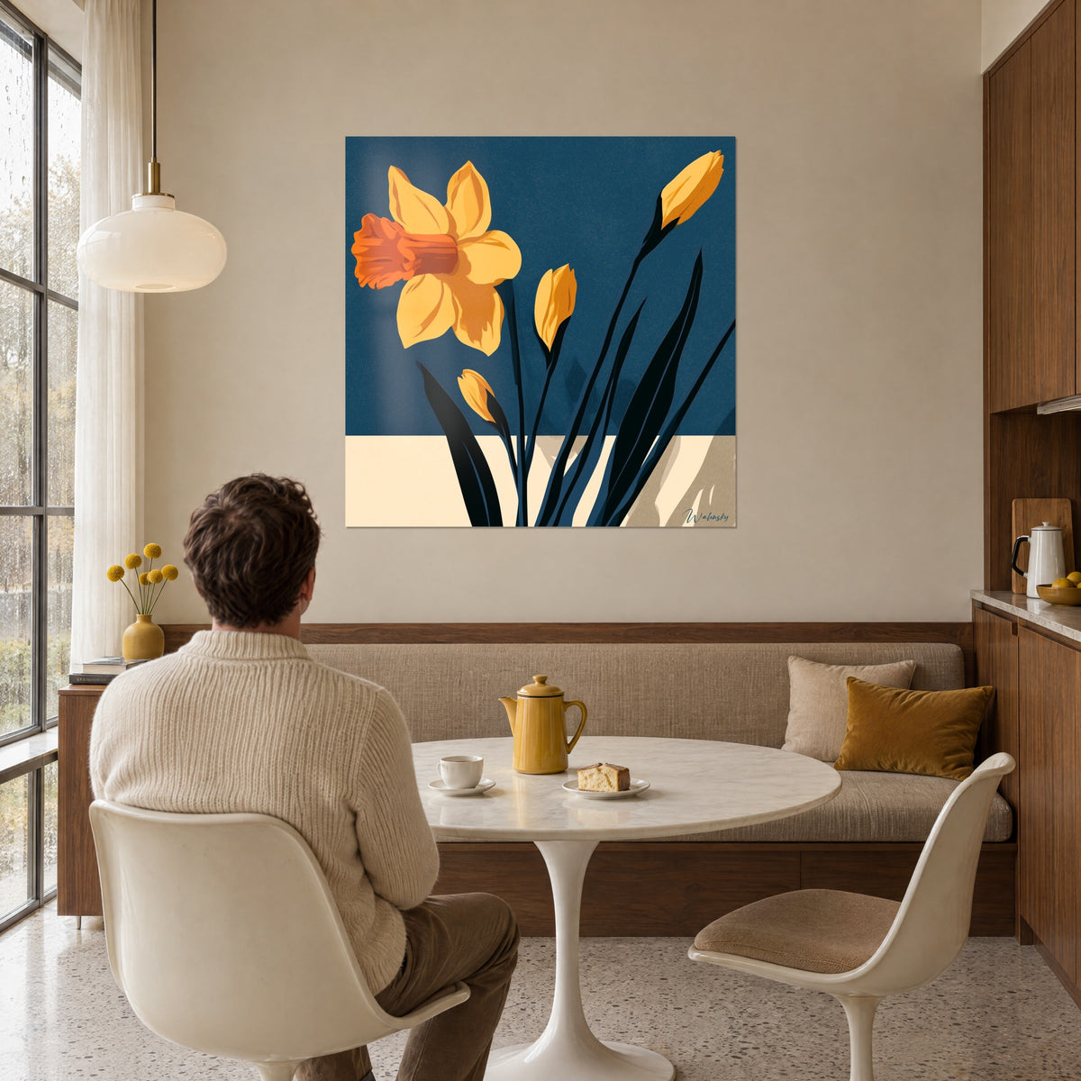 Tableau bouquet graphique de narcisses jaunes, feuilles noires et bandeau crème, un homme de dos à table, salle à manger aux murs beiges