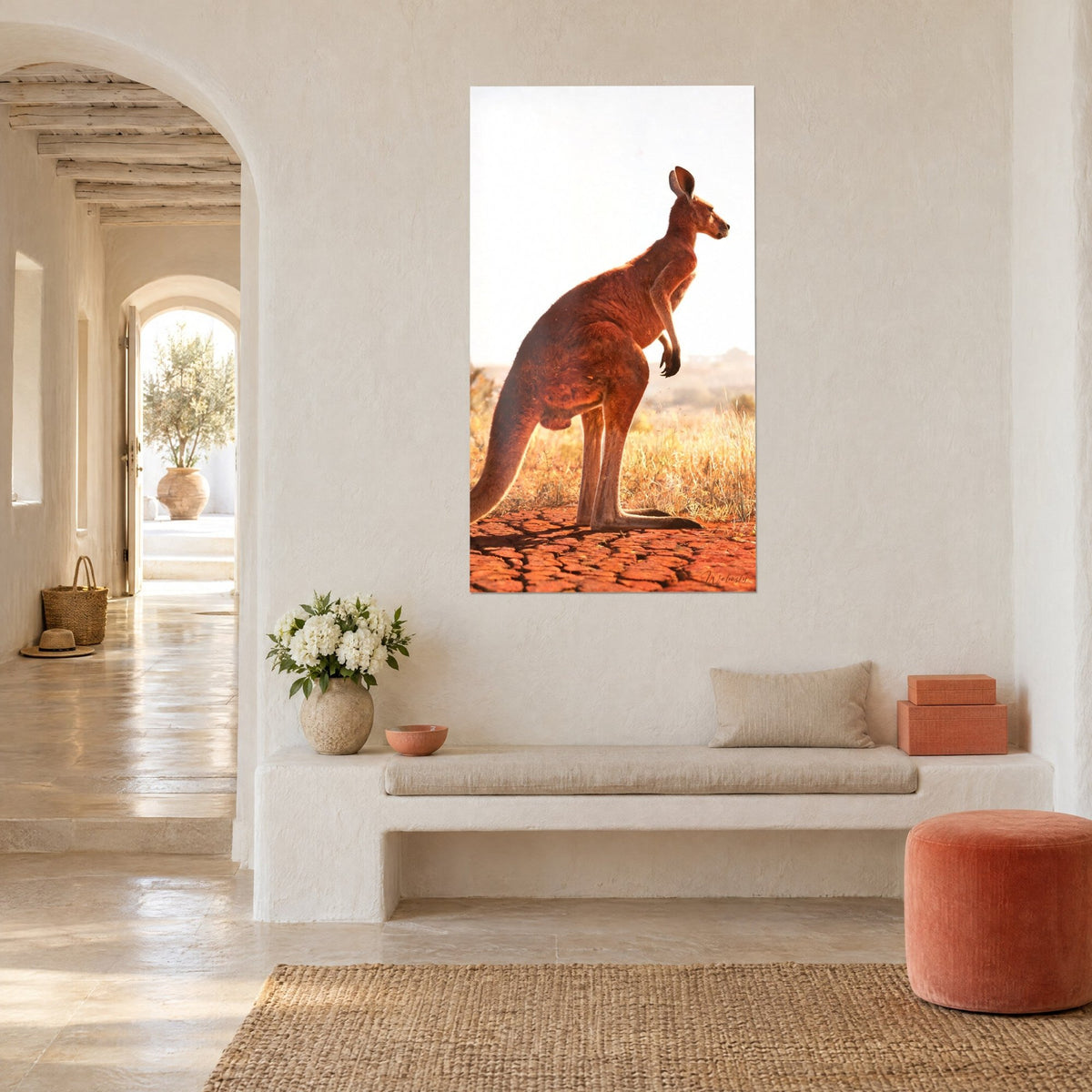 Tableau marsupial de profil au regard tourné vers l'horizon, roux cuivré et ciel blanc, mur crépi, banquette en pierre et jonc de mer