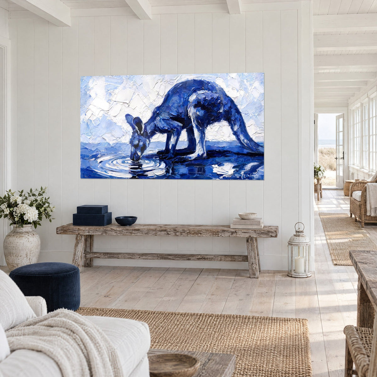 Tableau marsupial cobalt buvant, ondes concentriques argentées, mur blanc lambrissé, banc en bois brut dans une maison de bord de mer