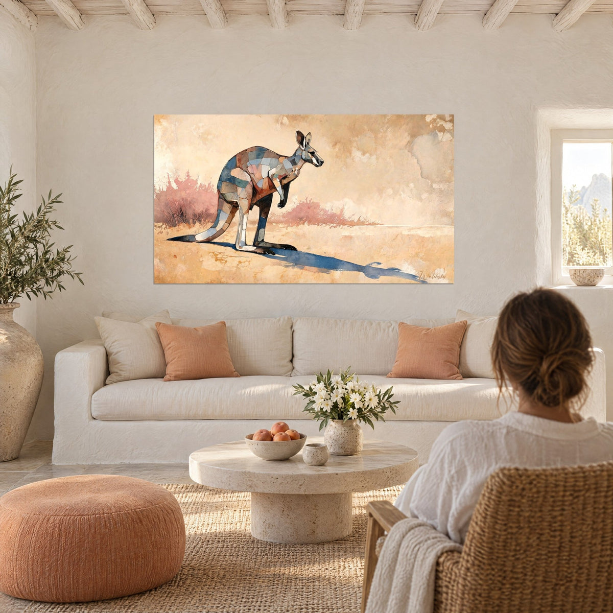 Wall art kangaroo in ochre and navy patchwork, indigo shadow on golden sand, above a sofa in a bright living room