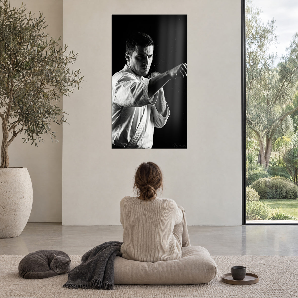 Cuadro de cinturón negro lanzando un puñetazo con la derecha, kimono blanco luminoso sobre negro intenso, en un salón con ventanal al jardín