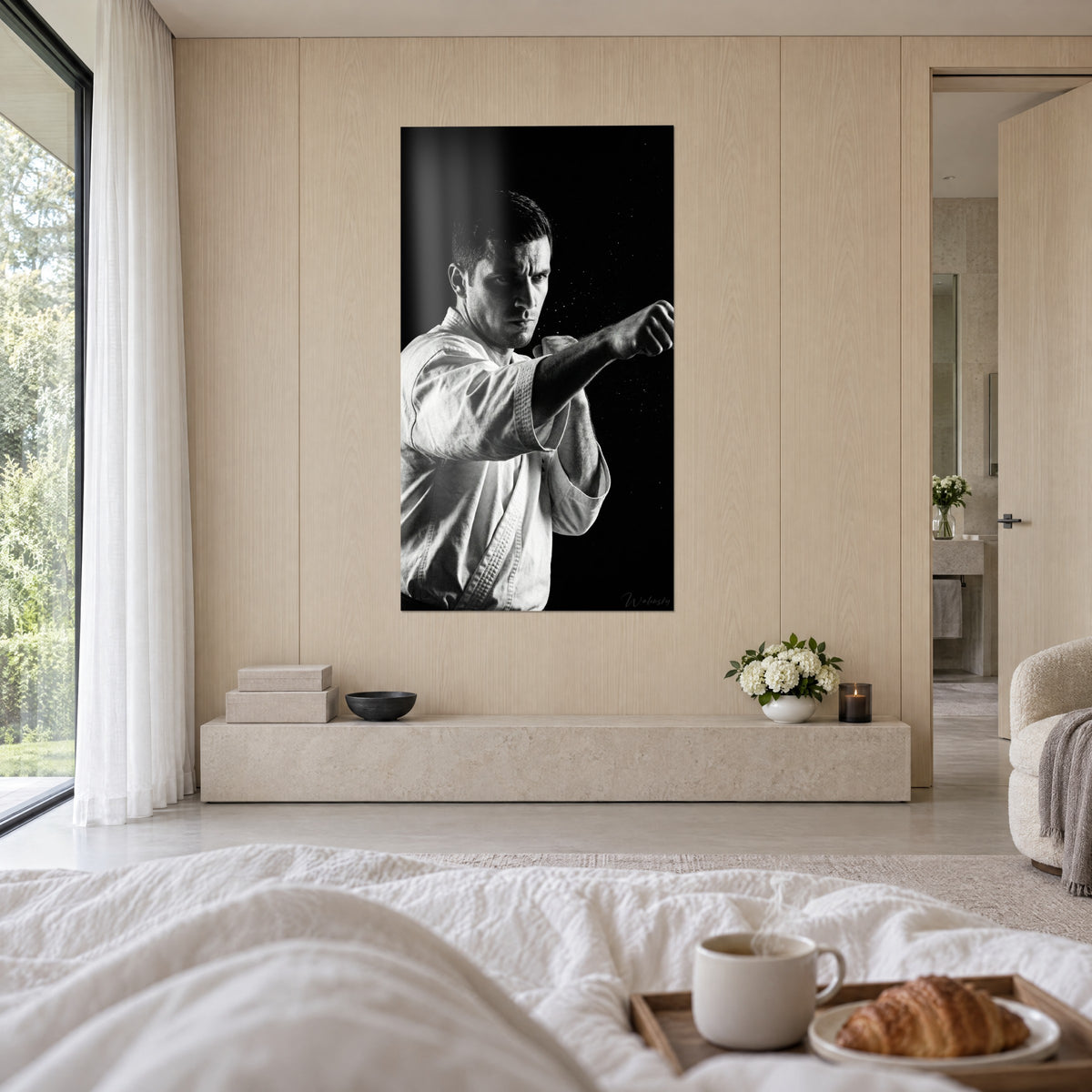 Cuadro de atleta de artes marciales con kimono claro, puñetazo en blanco y negro, firma plateada, encima de una cama en un dormitorio luminoso