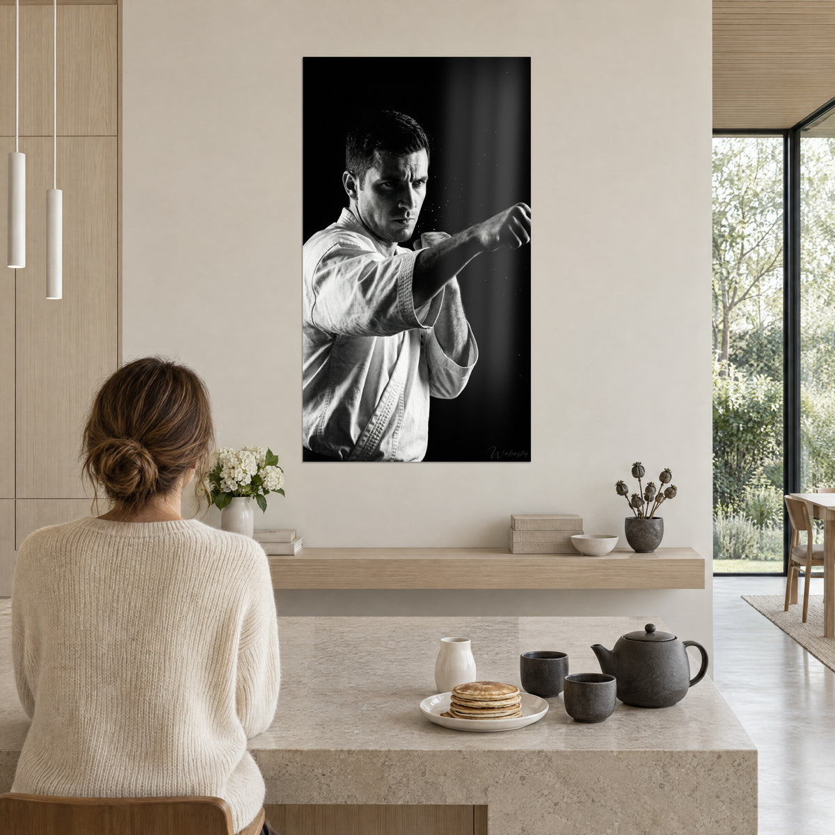 Cuadro retrato de un karateka concentrado, gotas blancas sobre fondo negro profundo, colgado en una cocina abierta de madera clara
