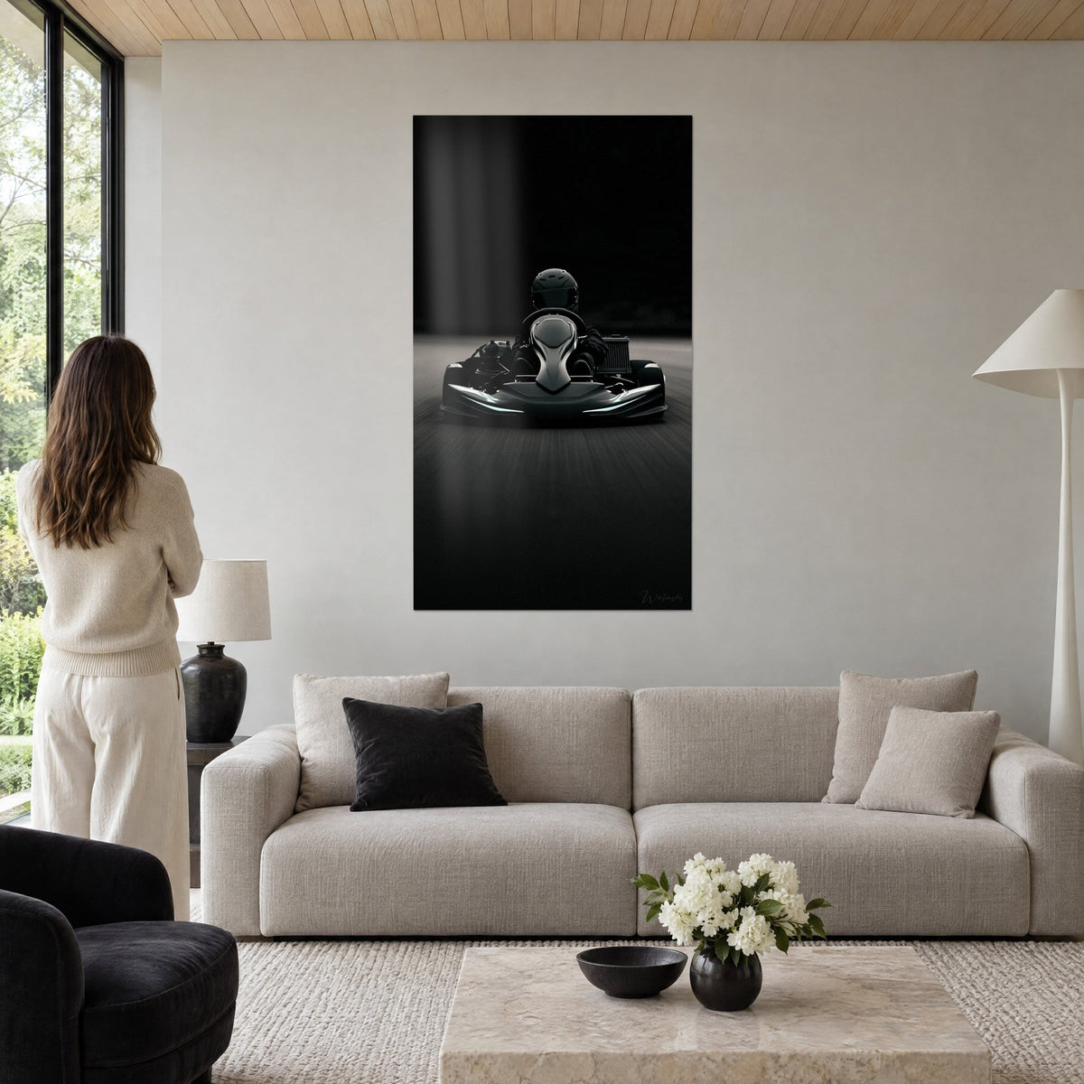 Tableau kart de course vu de face, carrosserie noire sculptée aux liserés turquoise, au-dessus d'un canapé dans un salon lumineux