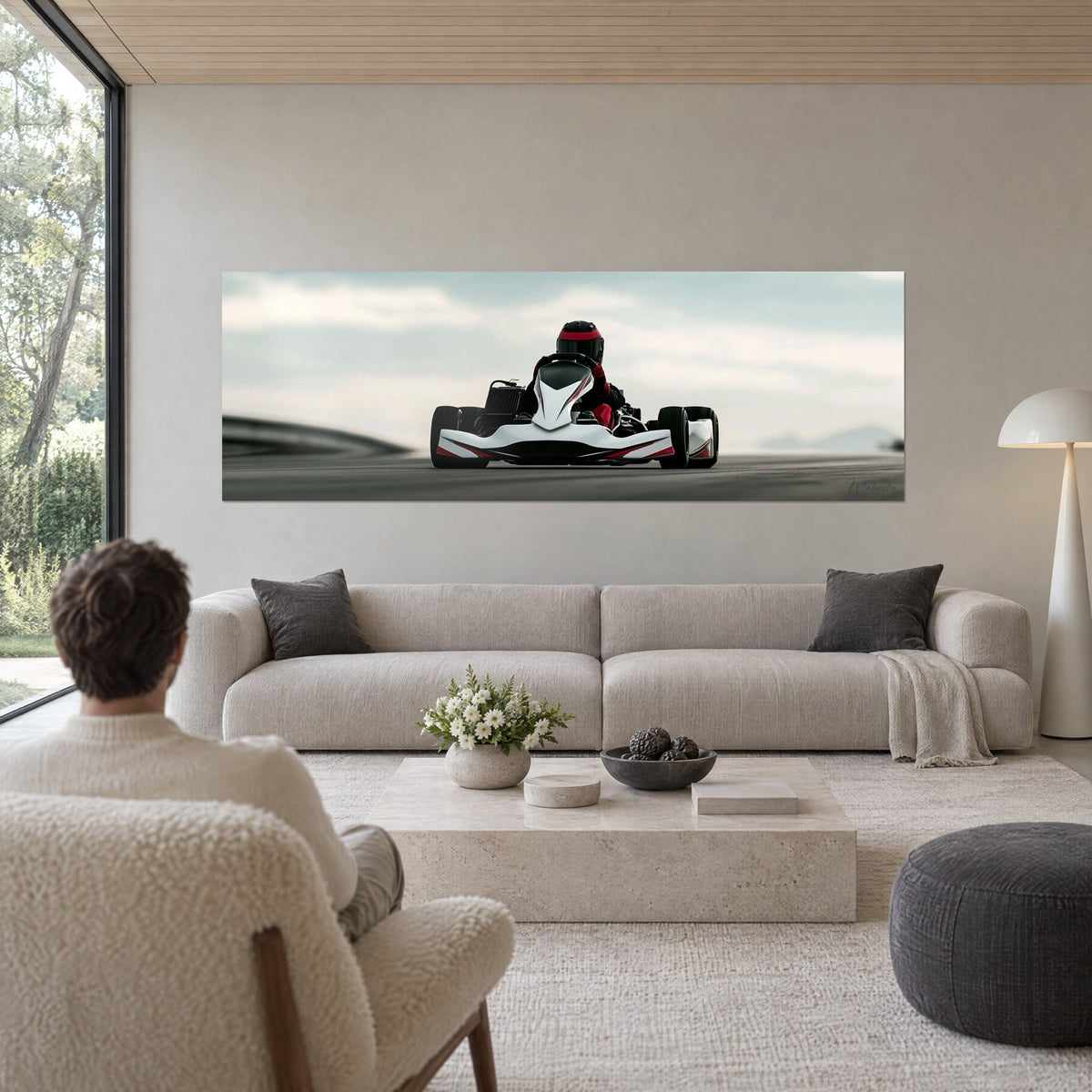 Cuadro kart de competición blanco y rojo, piloto con casco de frente sobre el asfalto gris, cielo nublado, encima de un sofá en un salón luminoso