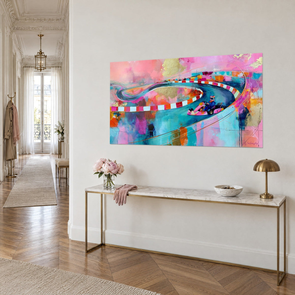 Schilderij van een kronkelend circuit met gouden accenten, rood-witte rand op roze en blauwe achtergrond, aan een beige muur naast een console