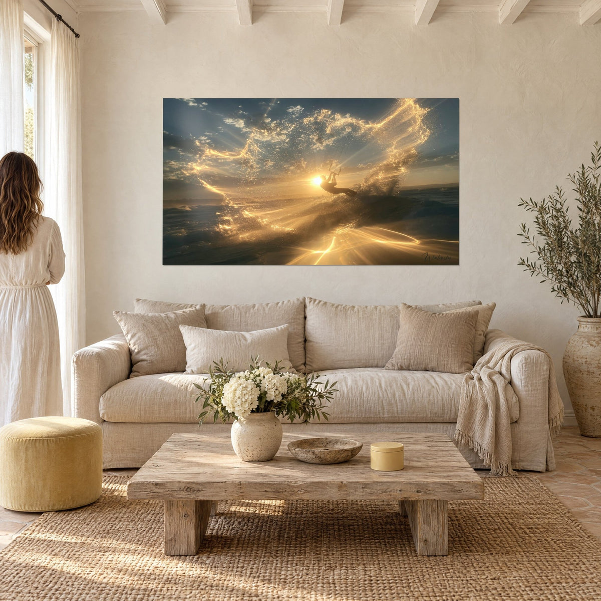 Wall art of a kitesurfer in silhouette on a wave, blue and gold sky, bright spray of foam, above a sofa in a sunlit living room