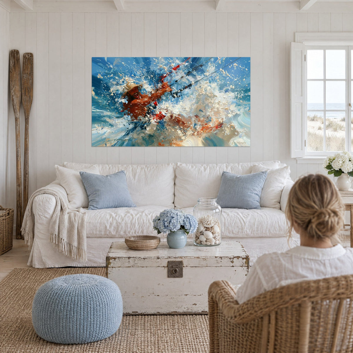 Tableau kitesurfeur hilare sous un chapeau de paille, gerbes d'écume blanche et bleu cobalt, au-dessus d'un canapé dans un salon lumineux