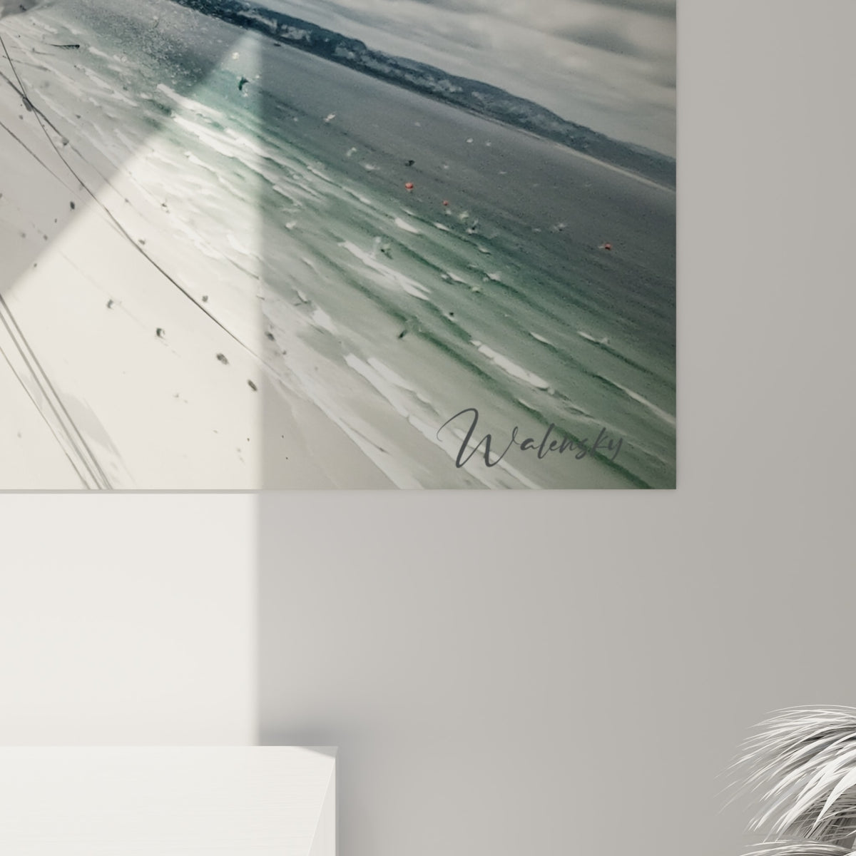 Traits granuleux gris anthracite et éclats rouge sang formant la silhouette du kitesurfeur, matière d'impression visible de près