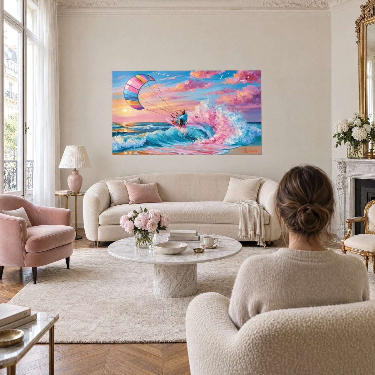 Tableau kitesurfeur en gilet bleu glissant sur une vague rose et turquoise, voile multicolore, au-dessus d'un canapé dans un salon lumineux