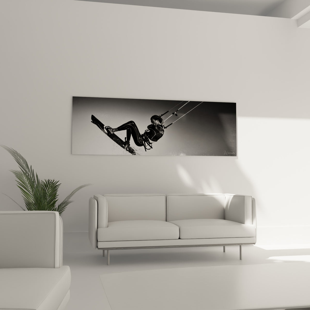 Sauteuse de kitesurf en noir profond capturée en plein mouvement, au-dessus d'un canapé dans un salon lumineux