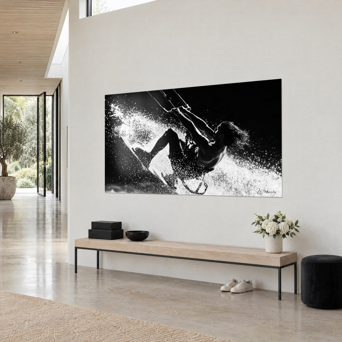 Tableau sportif cheveux longs au vent, planche inclinée dans les éclaboussures blanches sur fond noir, mur clair et banc en bois