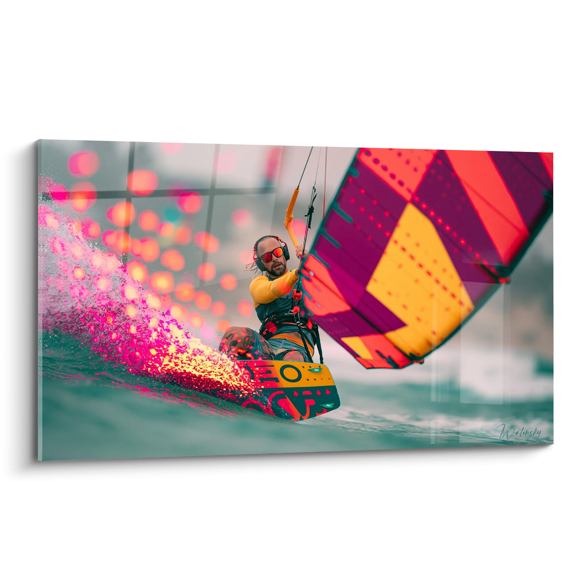 Kitesurfeur en action, sillage rose et doré, voile violette et jaune sur mer turquoise floutée