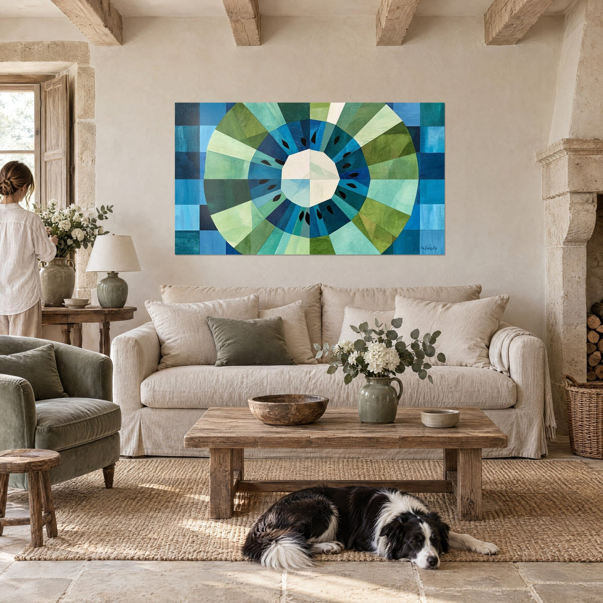 Wall art kiwi slice cut into a green and blue rosette, geometric rays, lying collie dog, above a sofa in a bright living room