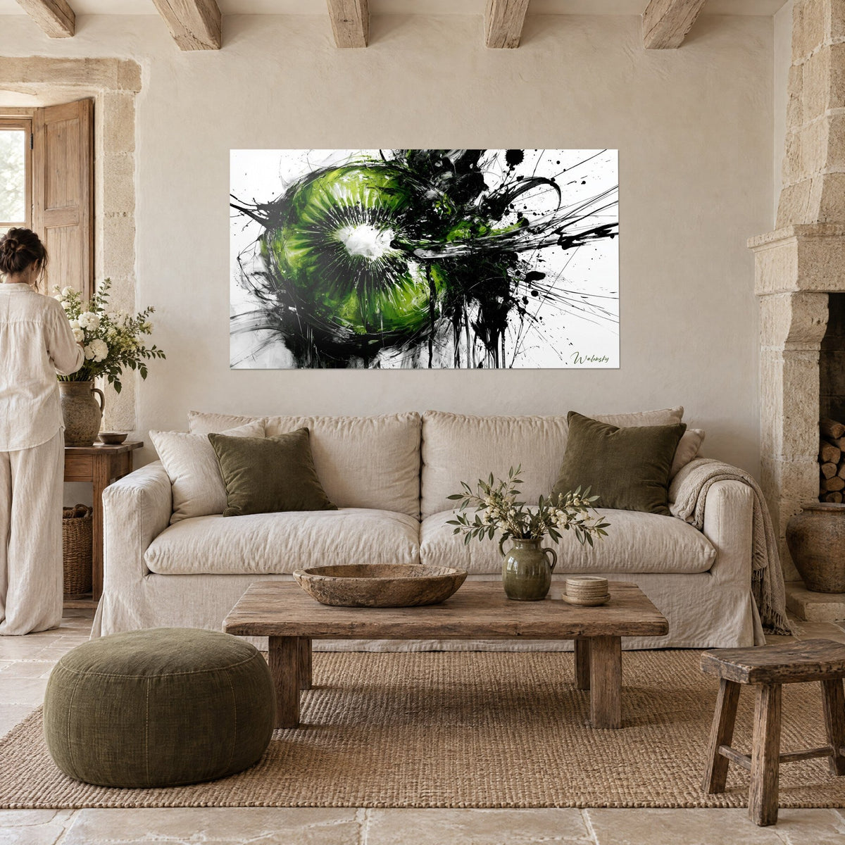 Wall art halved emerald kiwi splashed with black ink, white flesh at its heart, hung above a sofa in a bright living room