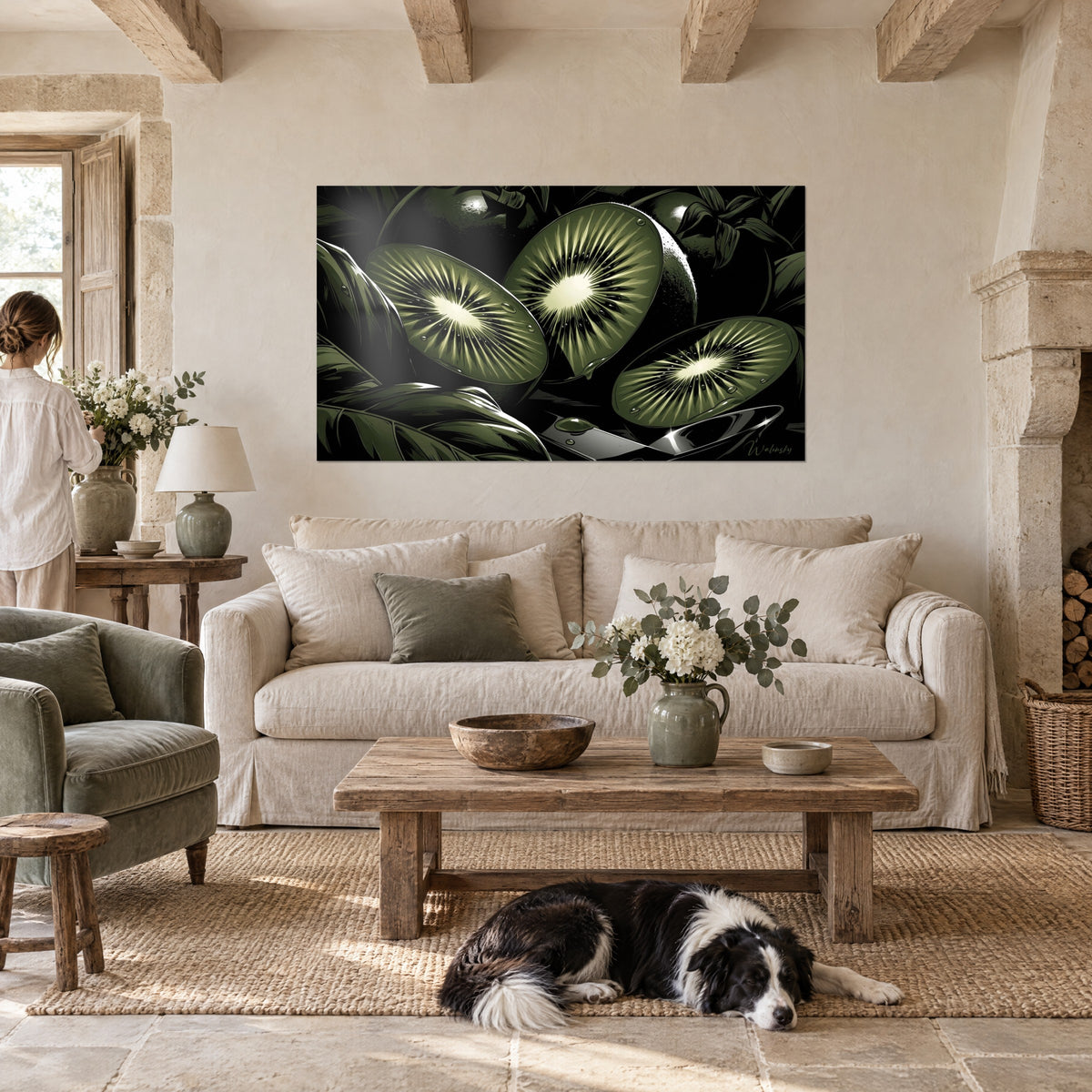 Tableau kiwis coupés aux rayons crème sur fond noir et vert olive, accroché avec une femme de dos et un collie, au-dessus d'un canapé dans un salon lumineux