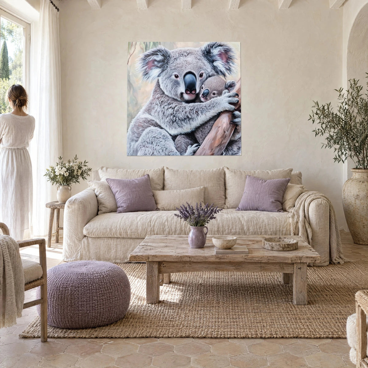 Wall art koala hugging its baby against its silvery grey fur, rosy cheeks, above a sofa in a bright living room