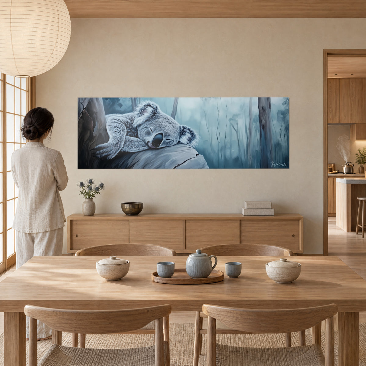 Gemälde friedlicher Koala mit flauschigen Ohren, graues Fell und blauer Nebel, vor einer Frau von hinten neben einem Holztisch