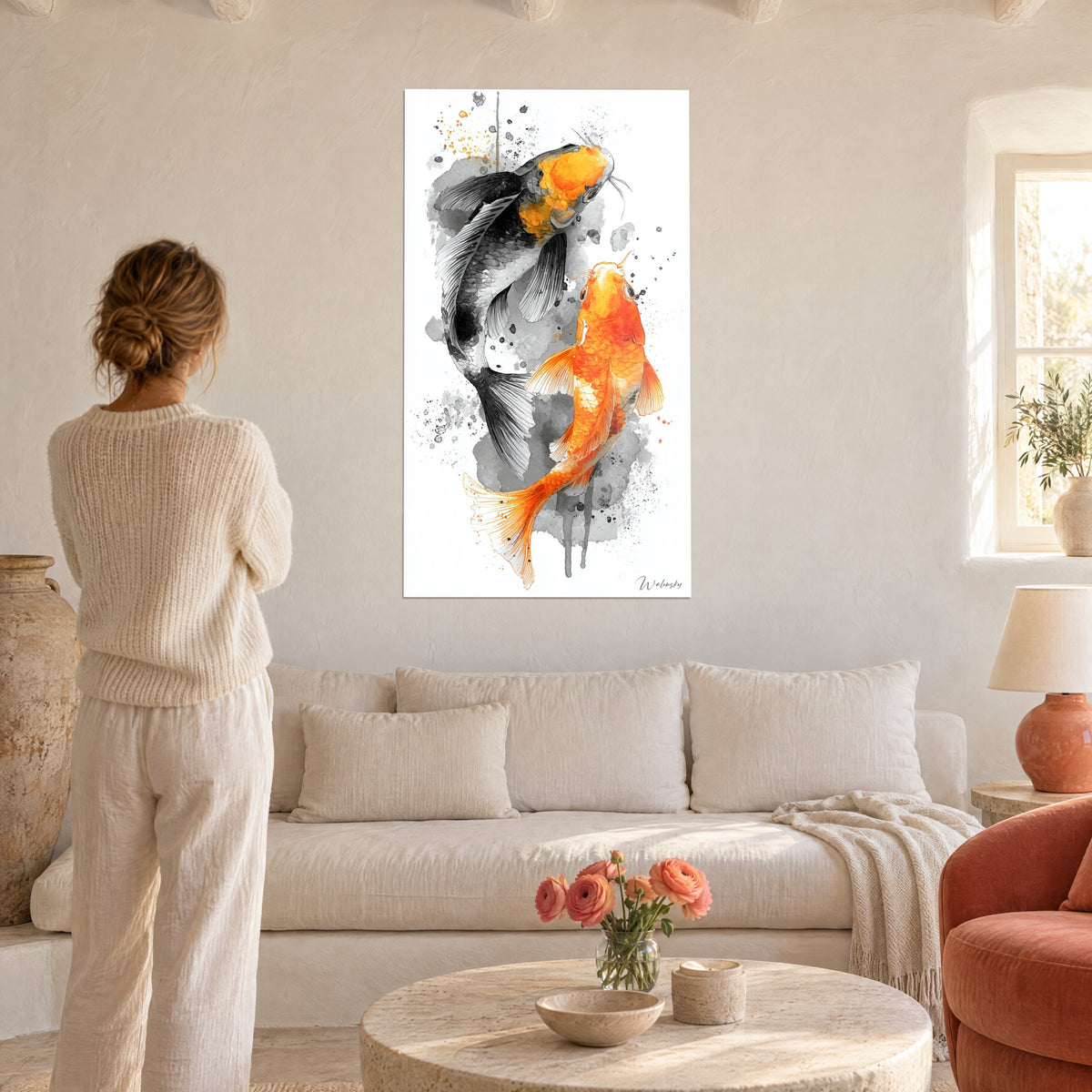 Cuadro carpa negra en tinta gris enfrentada a un koi naranja vivo, salpicaduras sobre fondo blanco, encima de un sofá en un salón luminoso