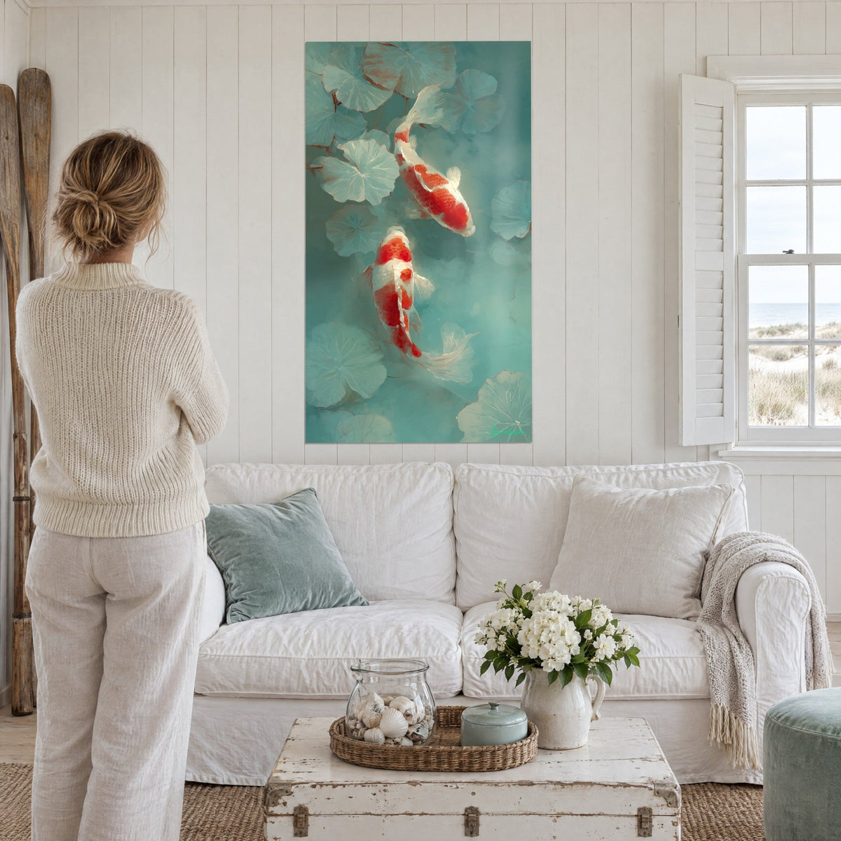 Wall art red and white koi carp gliding among celadon water lilies, a woman seen from behind above a sofa in a bright living room
