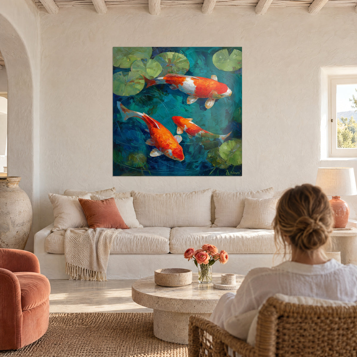 Wall art of orange and white koi carp swimming among green water lilies on turquoise water, woman seen from behind, above a sofa in a bright living room