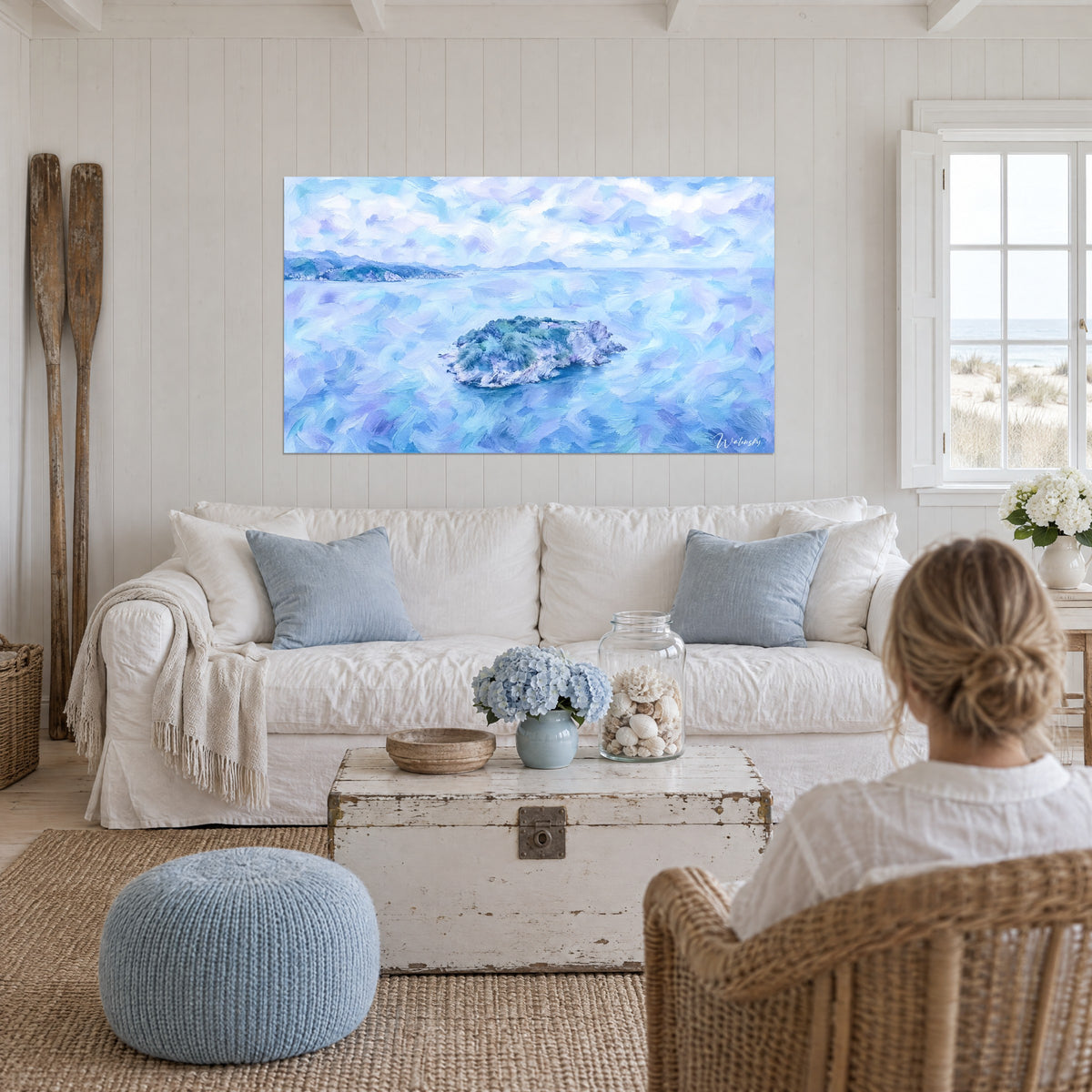 Schilderij rotseiland omringd door zee in blauw-lila en lavendel, dikke penseelstreken, boven een bank in een lichte woonkamer