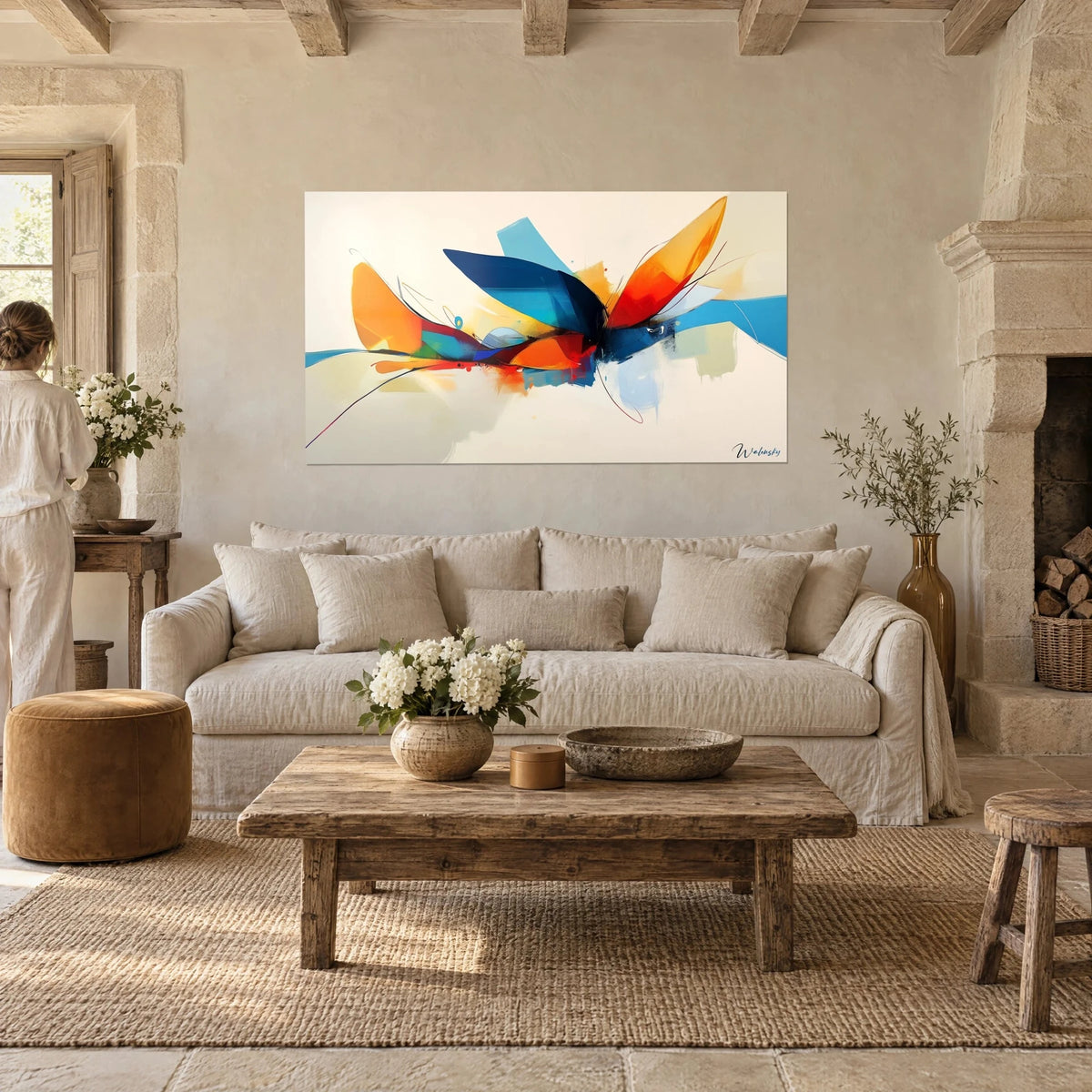 Wall art abstract navy blue and orange petals in bloom, figure seen from behind, above a sofa in a bright living room