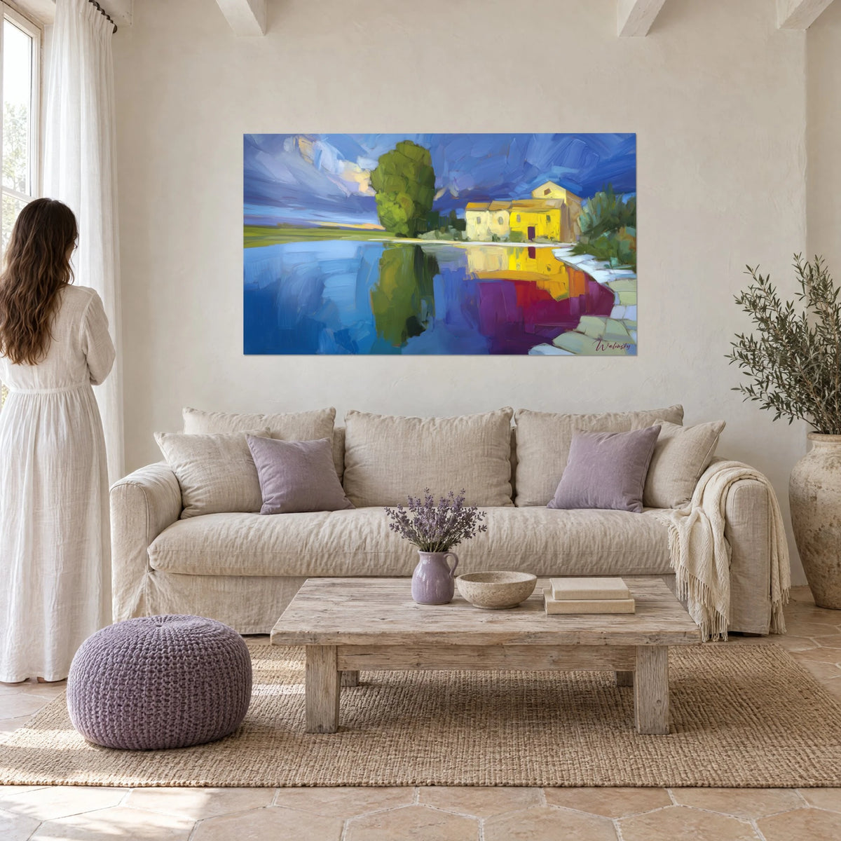 Tableau mas jaune citron au bord d'un lac bleu cobalt, reflets violets, une femme de dos, au-dessus d'un canapé dans un salon lumineux