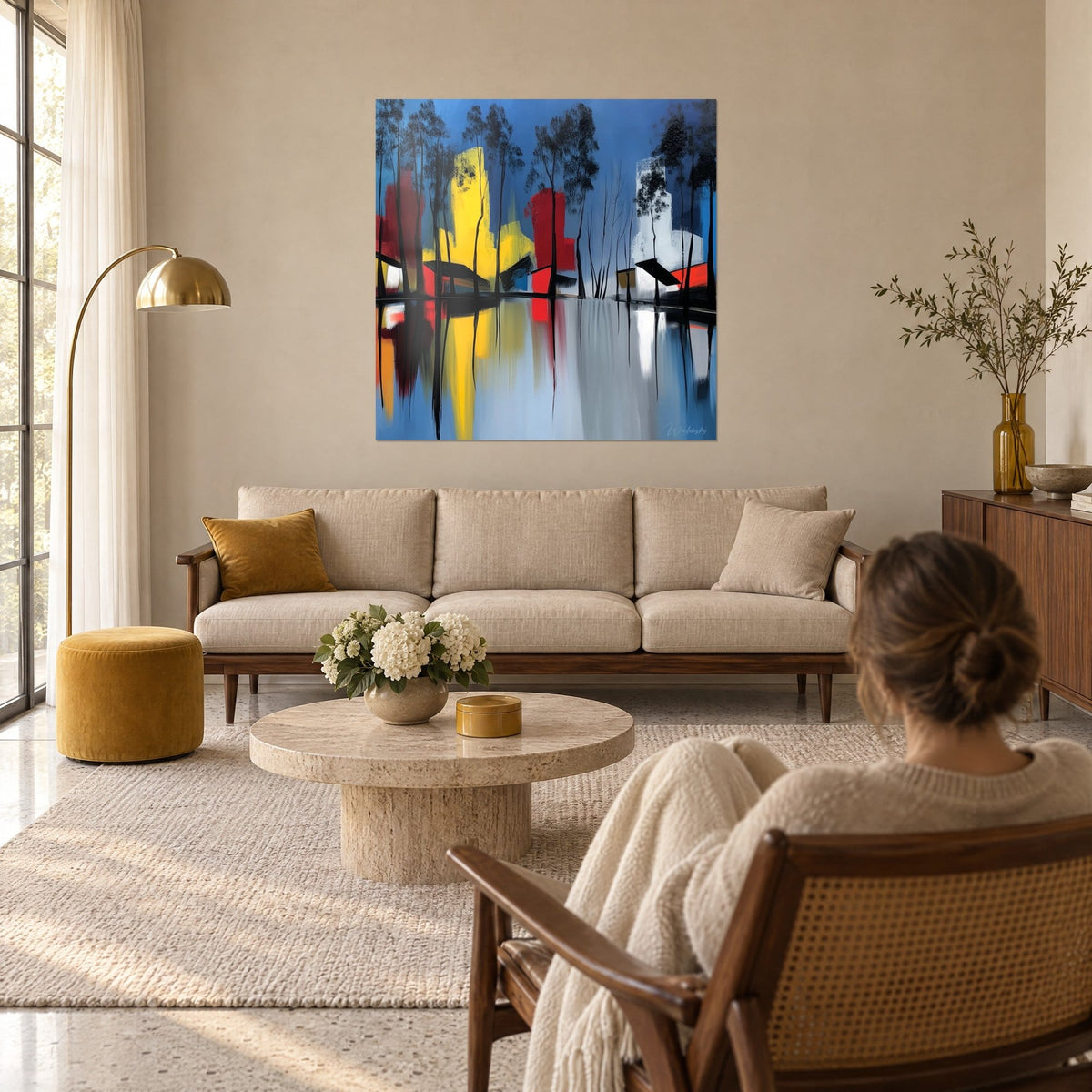 Quadro lago a specchio blu, tende di canne nere e blocchi gialli e rossi, due figure di spalle, sopra un divano in un soggiorno luminoso