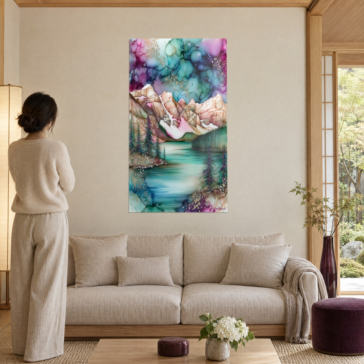 Cuadro lago de montaña en tinta de alcohol, cumbres rosas y ocres, agua turquesa, juncos dorados, sobre un sofá en un salón luminoso