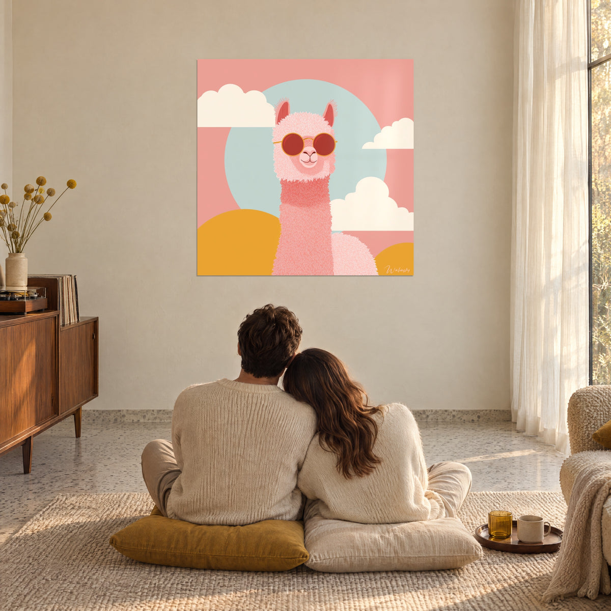 Gemälde Lama korallenrosa mit großer runder roter Brille, lachsfarbener Himmel und blaue Scheibe, Paar von hinten umschlungen auf ockerfarbenen Kissen am Boden