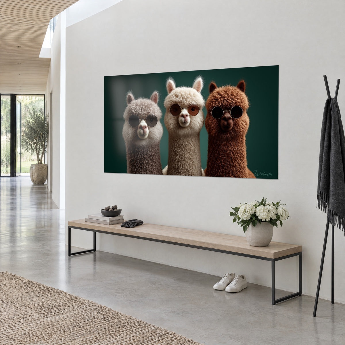 Cuadro tres llamas rizadas con gafas redondas, lana beige, gris y marrón delante de un fondo verde intenso, pared blanca y consola de madera