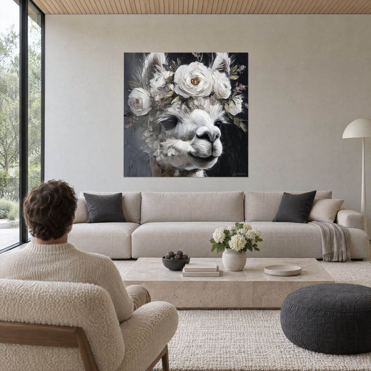 Quadro lama bianca a pittura a spatola, corona di rose avorio su fondo antracite, sopra un divano in un soggiorno luminoso