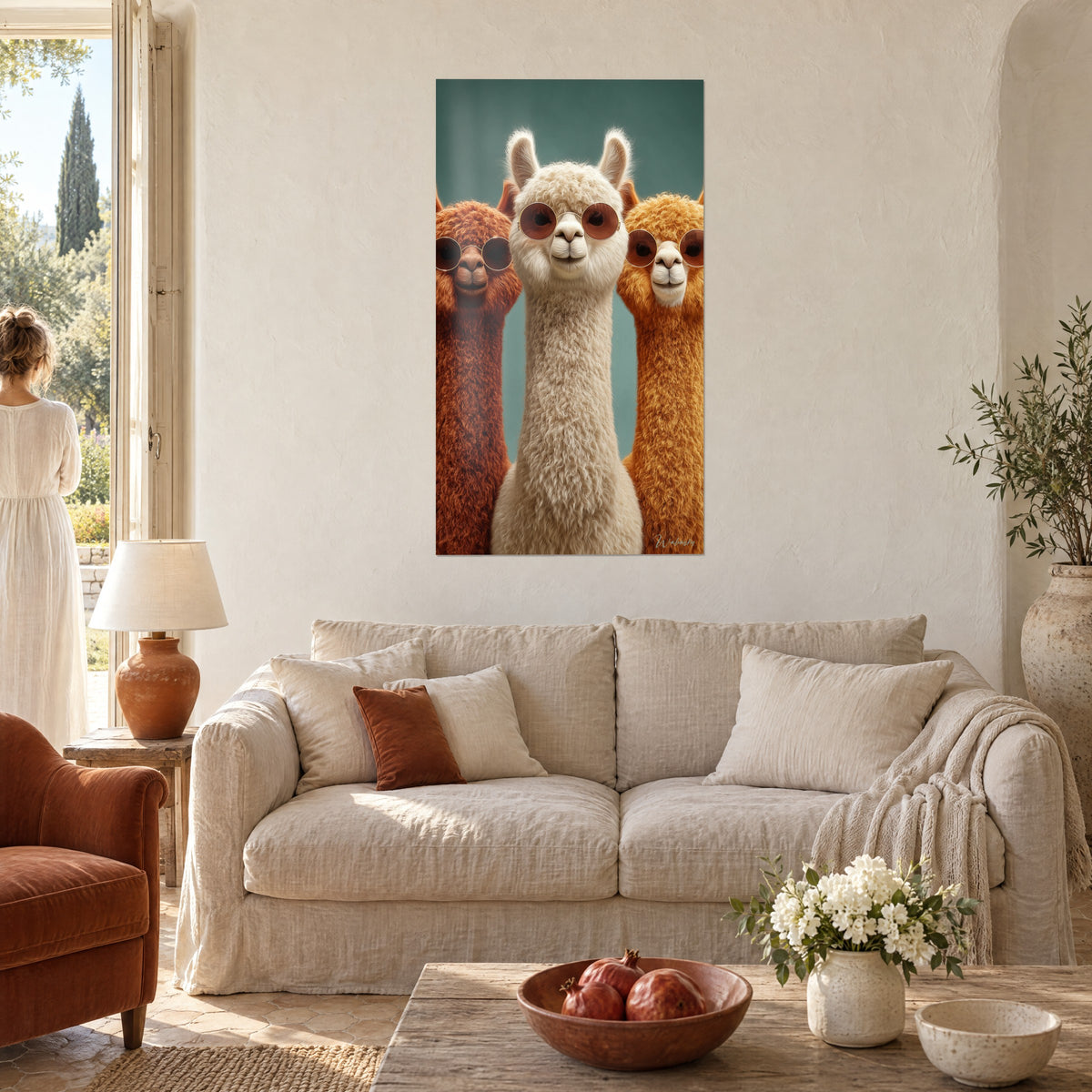 Cuadro trío de alpacas con gafas redondas, lana blanca y rojiza sobre fondo verde petróleo, encima de un sofá en un salón luminoso